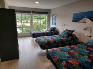 ein Zimmer mit zwei Betten und einer Couch und einem Fenster in der Unterkunft Apartamento Vistas Pedrido in Paderne