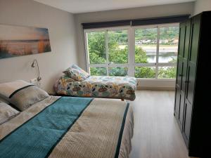 ein Schlafzimmer mit einem Bett und einer Couch und einem Fenster in der Unterkunft Apartamento Vistas Pedrido in Paderne