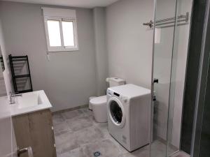 ein Badezimmer mit Waschmaschine und Toilette in der Unterkunft Apartamento Vistas Pedrido in Paderne