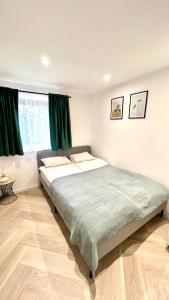 een slaapkamer met 2 bedden en groene gordijnen bij Apartament 21 in Szczyrk