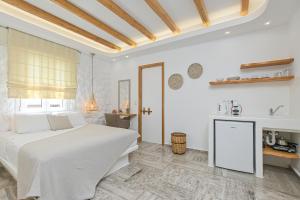 a white bedroom with a bed and a table at Blue Sky Summer in Naxos Chora