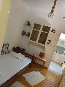 a bedroom with a bed and a table and a window at EVRIAKI'S HOUSE in Apidias Lakos