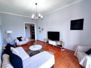 uma sala de estar com um sofá e uma televisão em Sea & Sun - 4th floor comfy apartment, great view em Preveza