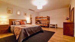 ein Schlafzimmer mit einem Bett und einem Etagenbett in der Unterkunft Casa do Moleiro in Lousã