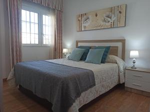 um quarto com uma cama grande e almofadas azuis em Novedad Suite Céntrico con Porche y Jardín em Torremolinos