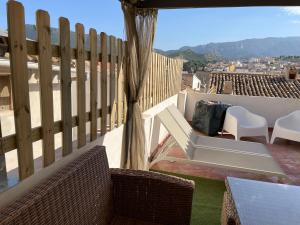 einen Balkon mit Stühlen, einem Tisch und einem Zaun in der Unterkunft Casa Rural Villa Leire en pleno corazón del Valle Ricote in Blanca