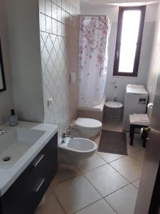a white bathroom with a toilet and a sink at Il Rifugio di Farinella in Putignano