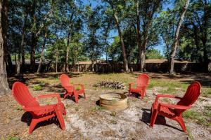 a group of red chairs around a fire pit at Moody Oaks in Orange Park
