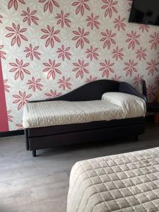 łóżko w sypialni z kwiatową tapetą w obiekcie Hotel Vera w Cesenatico +24 zdjęcia