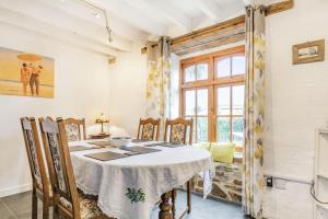ein Esszimmer mit einem Tisch, Stühlen und einem Fenster in der Unterkunft Victoria Cottage in Newquay