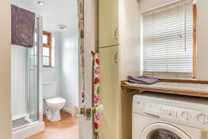 a bathroom with a washing machine and a toilet at Victoria Cottage in Newquay +17 photos