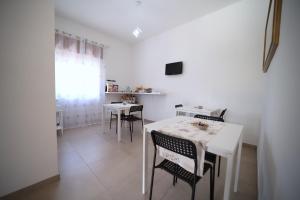 a dining room with a white table and chairs at B&B VANNEFORA in San Nicola Arcella