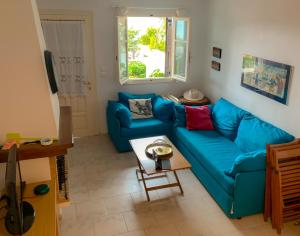 a living room with a blue couch and a table at Endless Blue Maisonette in Agios Ioannis Pelio