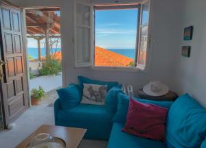 a blue couch in a living room with a window at Endless Blue Maisonette in Agios Ioannis Pelio