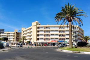 a palm tree in front of a large building at CANARIAN HOLIDAY HOME - Yumbo Luxury Apartment in Maspalomas