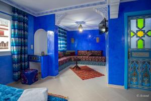 a blue room with a couch and a door at Puerta Azul in Chefchaouen