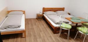 two beds in a room with a table and chairs at Booking Tržní in Děčín