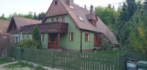 una casa con una valla delante de ella en DOMEK POD ŚMIELCEM, en Jelenia Góra-Jagniątków