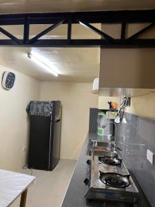 a kitchen with a stove and a black refrigerator at Serenity House in Baguio