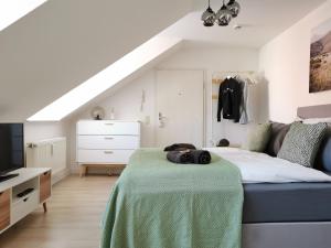 Un dormitorio con una cama con una manta verde. en Fynbos Studio DG in der Altstadt, Frauenkirchenblick, Parkplatz, en Meißen