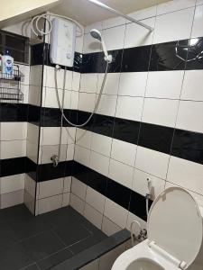 a bathroom with a black and white tiled wall at Serenity House in Baguio