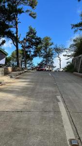 an empty street with trees on the side of the road at Serenity House in Baguio