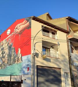 un mural en el lateral de un edificio en B&B S'Apposentu en Arbus