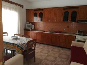 a kitchen with wooden cabinets and a table with a table cloth at House in Vlorë