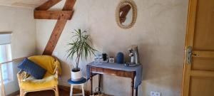 een kamer met een tafel, een stoel en een spiegel bij Le Coq en Repos in Saint-Sylvestre-sur-Lot