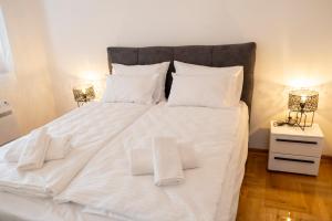 a large white bed with white pillows on it at Apartment Elite Residence in Mostar