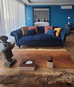 a blue couch in a living room with a bed at Appartements Lamblin in Abidjan