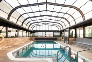 a large swimming pool in a large building at Gran Hotel Luna de Granada in Granada