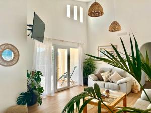 a living room with a couch and potted plants at Villa Ona in Son Bou