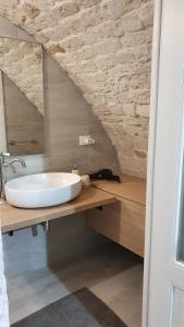 a bathroom with a sink and a stone wall at DIMORA PATRIZIA in Triggianello