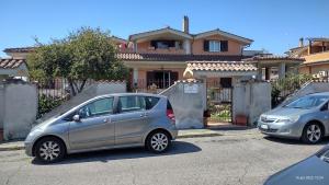 twee auto's geparkeerd voor een huis bij Villa Grazia in Ladispoli