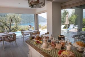 a kitchen with a breakfast table with a view of the ocean at Verdolivo in Sale Marasino