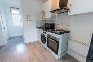 a kitchen with a stove and a washing machine at Flat 04 Studio flat close to Aylesbury town and Station Free Parking in Buckinghamshire