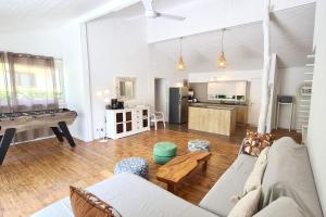 a living room with a couch and a pool table at Cottage Manua in Temae