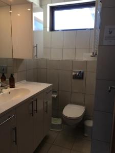 un bagno con lavandino, water e finestra di The Writer´s Nest a Grundarfjordur