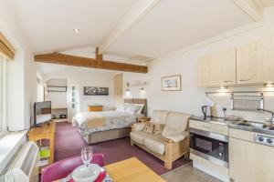 a kitchen and living room with a bed and a couch at The Friendly Room in Austwick