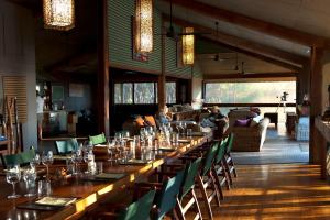 a long table in a room with chairs and people at Bamurru Plains in Point Stuart
