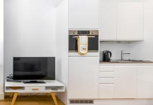 een keuken met witte kasten en een tv op een tafel bij 602 Luxury Apartment near Luton Town and Station in Luton