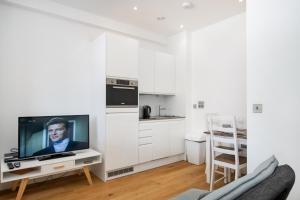 a living room with a tv and a kitchen at 602 Luxury Apartment near Luton Town and Station in Luton