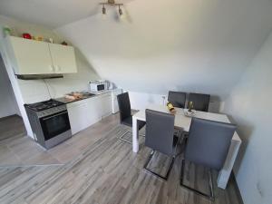 a kitchen with a table and chairs and a stove at Apartments Sertic 4 stars in Poljanak
