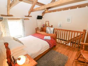 a bedroom with a bed and a wooden staircase at Bwthyn Y Felin Star in Clydey