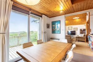 a dining room with a table and a large window at Thorsvik in Teangue