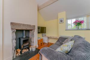 a living room with a couch and a fireplace at Quarry Cottage in Llanasa