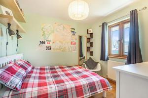 a bedroom with a red and white plaid bed at Gorwel in Blaenau-Ffestiniog