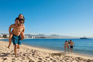 a man carrying a woman on a beach at Breathless Cabo San Lucas - Adults Only in Cabo San Lucas