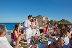 a group of people standing around a table with food at Breathless Cabo San Lucas - Adults Only in Cabo San Lucas